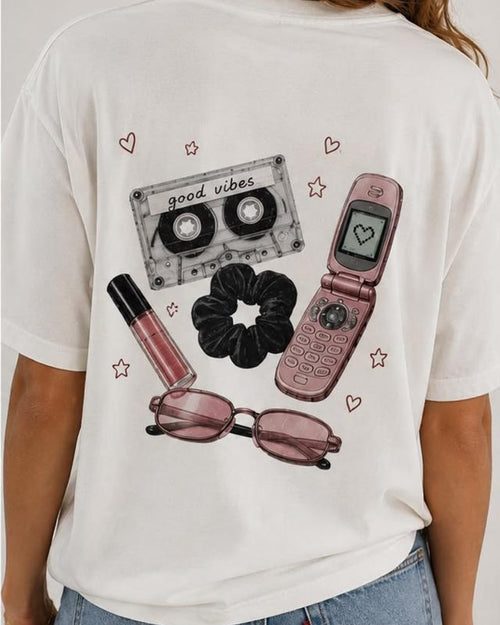 Costas da camiseta 90's Girl com fita cassete, celular e acessórios ilustrados