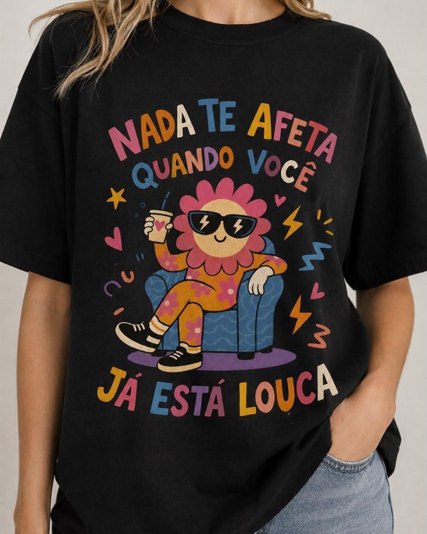 Camiseta preta com estampa colorida: flor de óculos escuros sentada numa poltrona e a frase Nada te afeta quando você já está louca