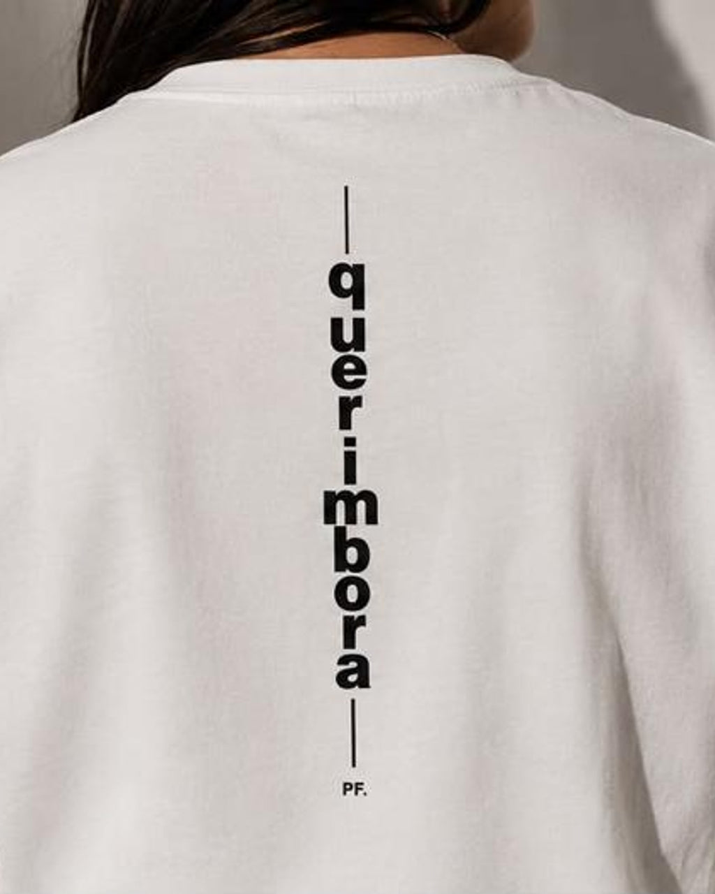 Costas da camiseta Querimbora com a palavra impressa na vertical ao longo da coluna